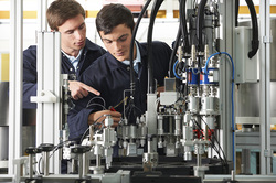 A young man and teacher in a robotics laboratory