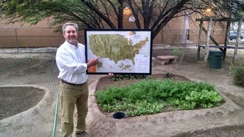 YouthWorks Charter High School principal holding a national community garden map where the school is listed